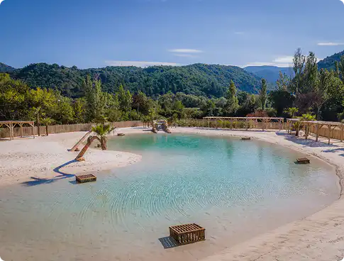 A campground lagoon with a communal sand beach, families enjoying the water