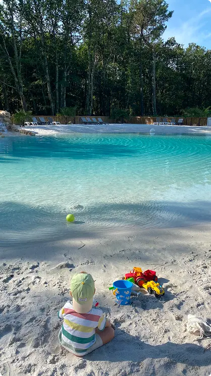 A completed Clair Lagon lagoon in portrait view showing turquoise water, sandy beach and natural landscape integration