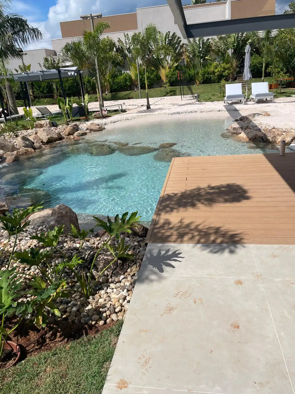 A completed Clair Lagon lagoon surrounded by lush natural forest, portrait orientation