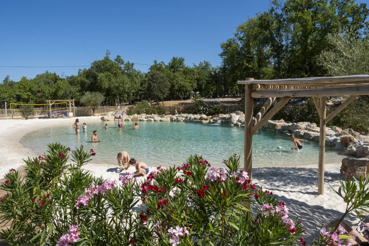 A completed Clair Lagon premium lagoon installation with expansive sand beach and deep swimming zone