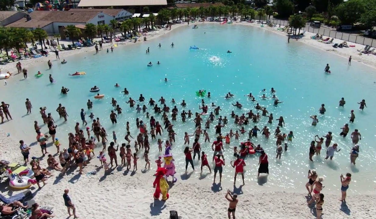 A filled, commissioned lagoon at first swim, calm turquoise water and warm sand