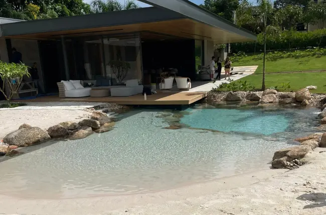 A Mediterranean-style lagoon with natural rock selection along the shoreline in warm sunlight